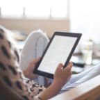 woman sitting on chair using black ipad